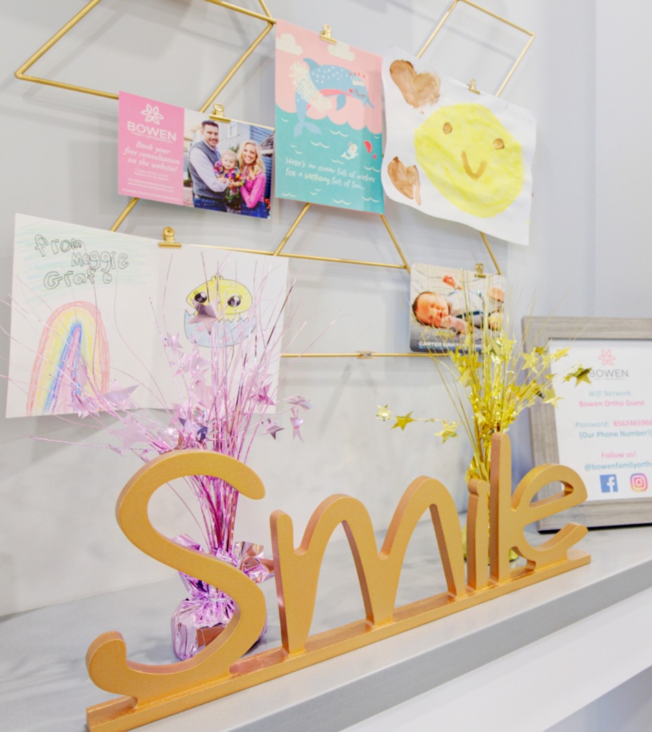 front desk with flowers and smile sign on counter