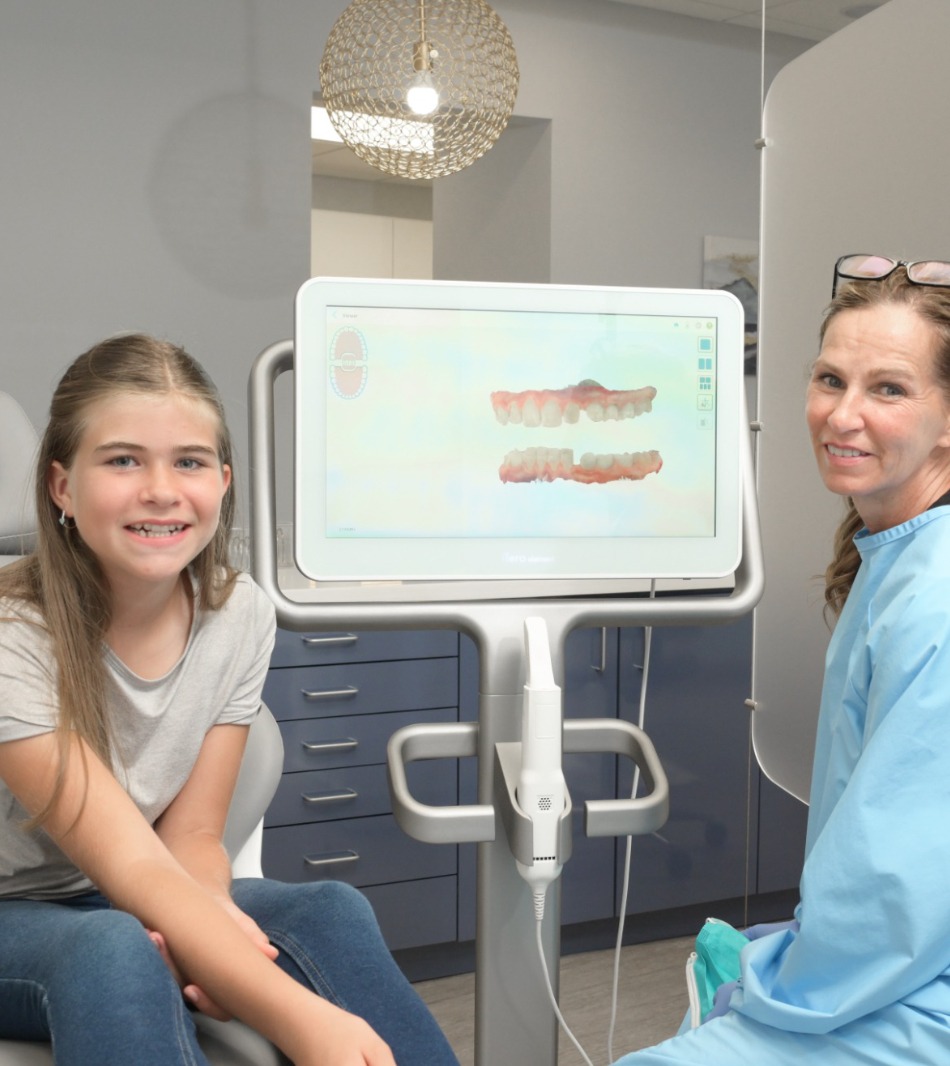 teen patient smiling and looking at orthodontic scans