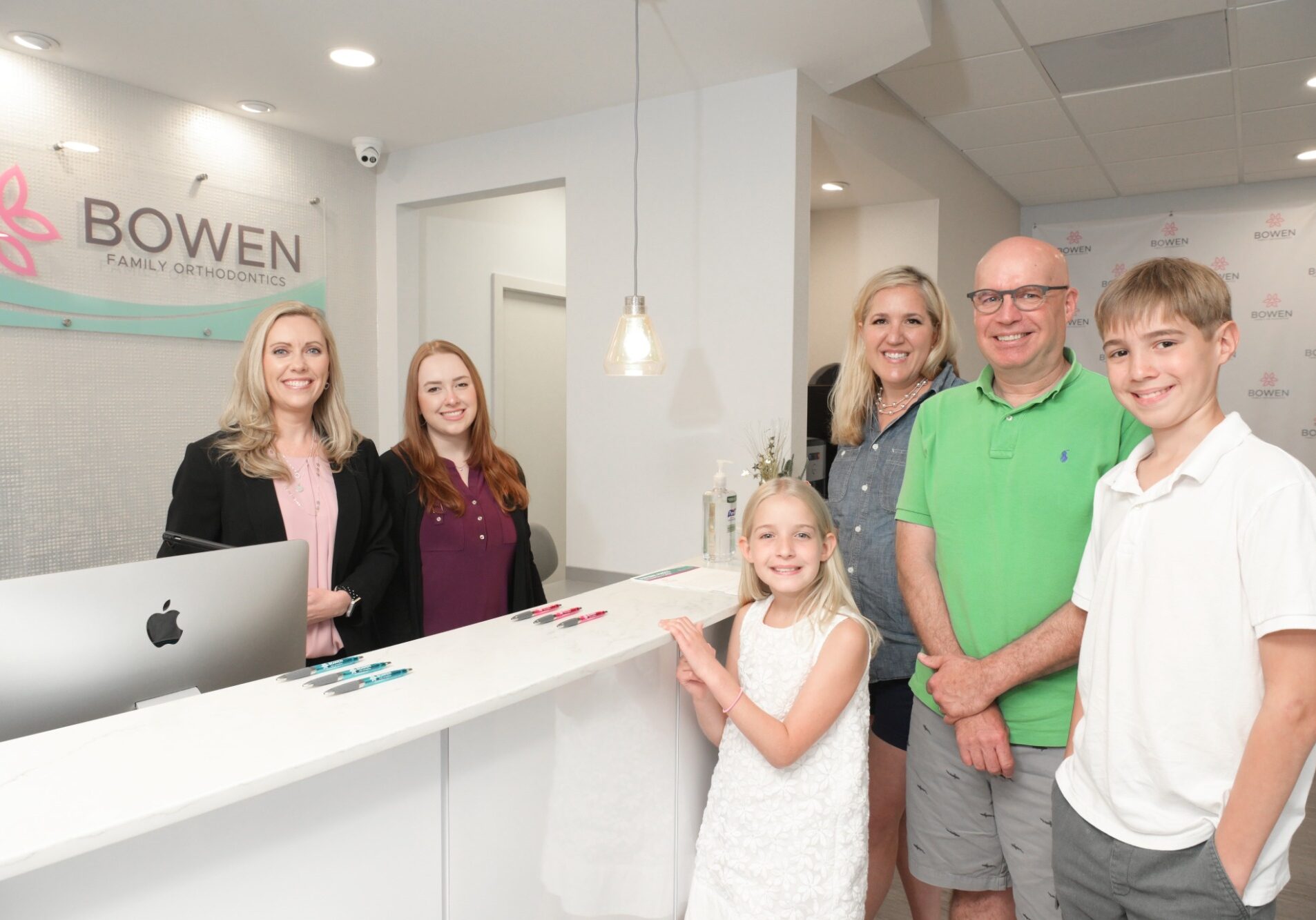 Bowen Family Orthodontics team welcoming patients at the reception, featuring Dr. Jessica Bowen with staff and a family, highlighting friendly orthodontic care in Mullica Hill, NJ.